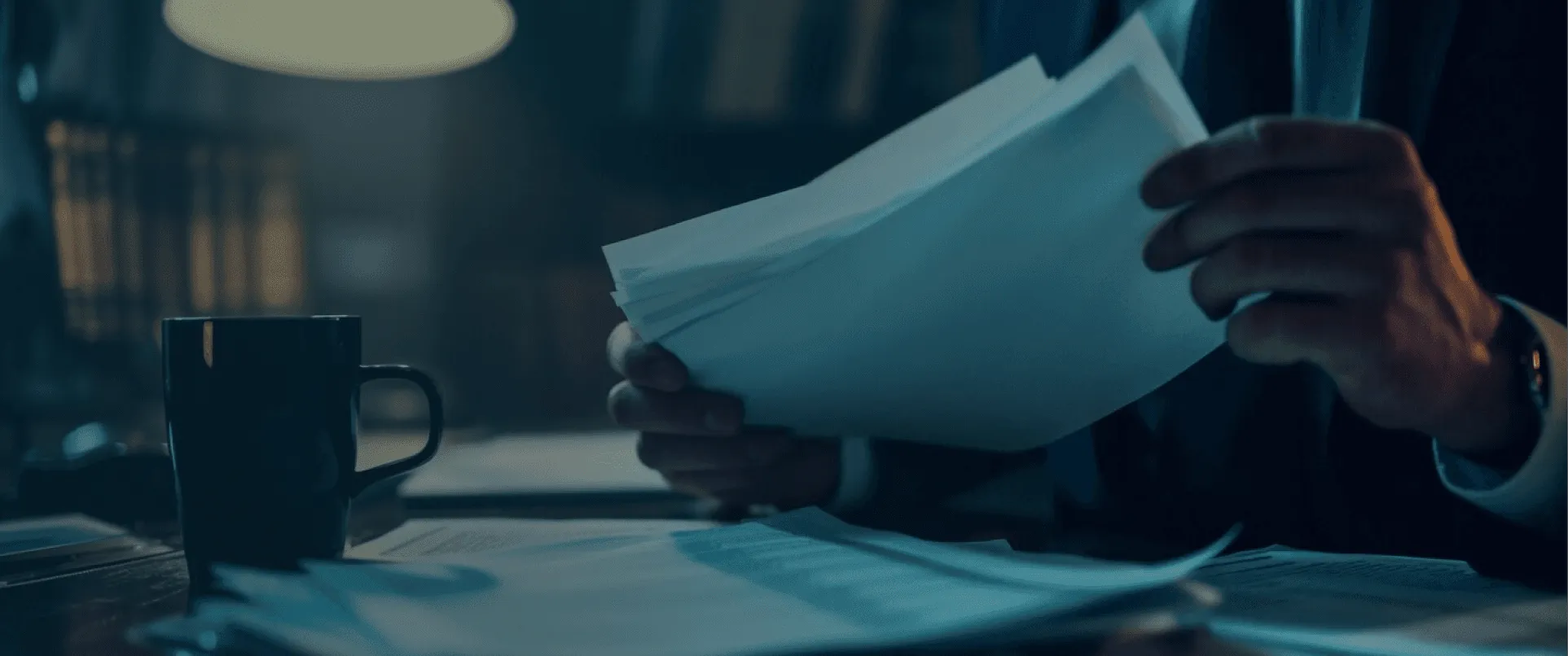 Hands sorting printed documents at a desk
